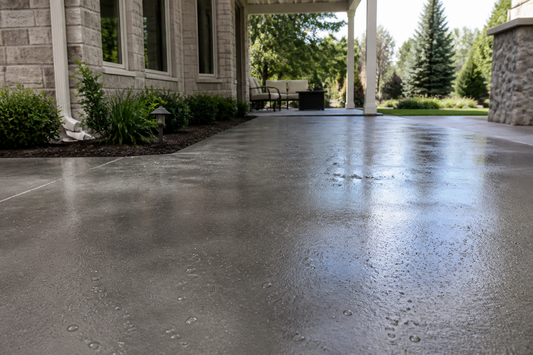 Sealed concrete patio with a satin sheen and water beading on the surface