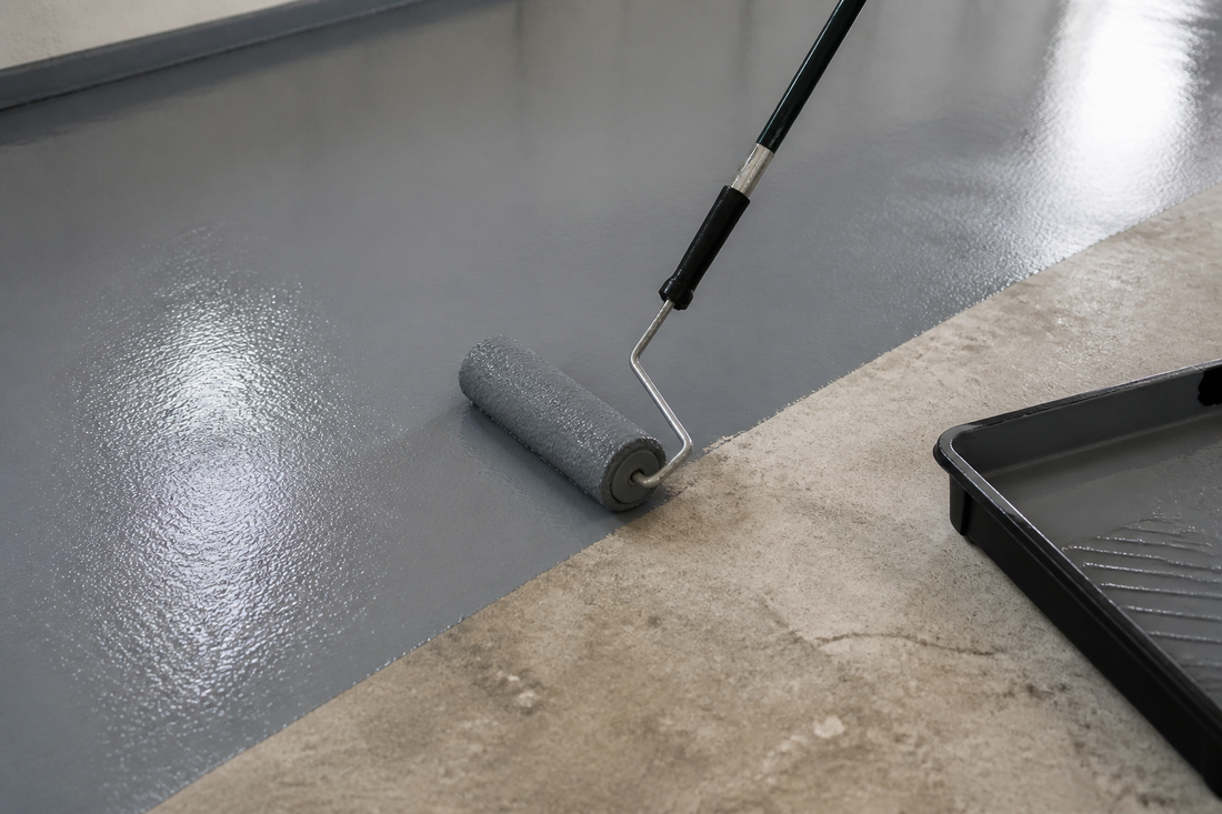 Roller applying grey floor paint onto a prepared concrete floor