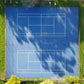 Two Blue Tennis Courts surrounded by green grass