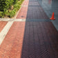 Completed stone sealer application on large red paver walkway with satin sheen finish