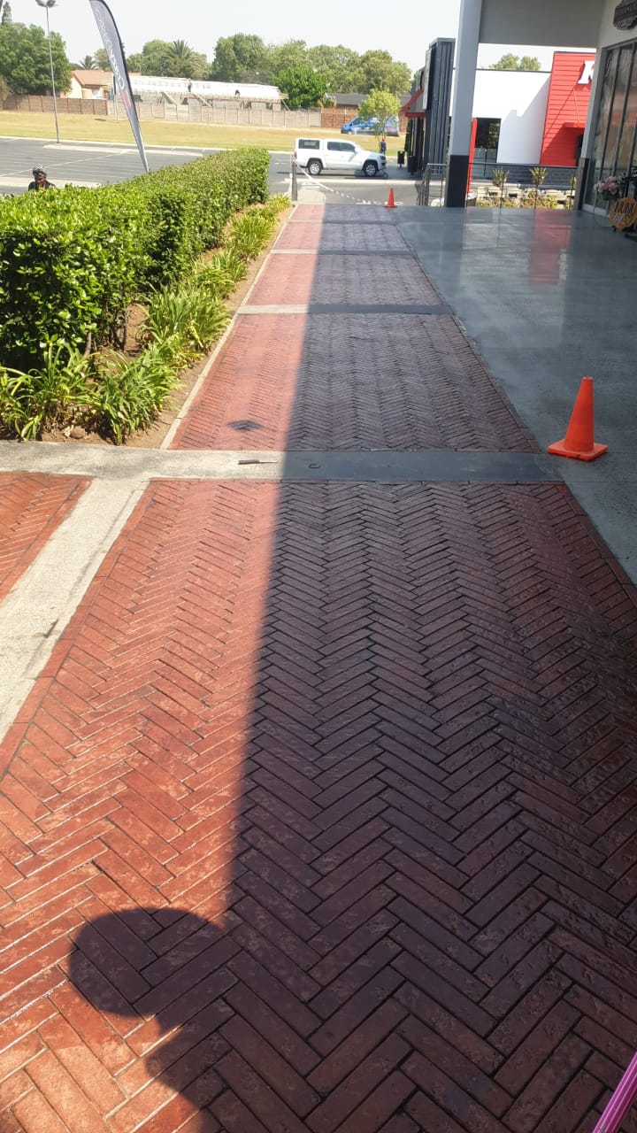 Completed stone sealer application on large red paver walkway with satin sheen finish