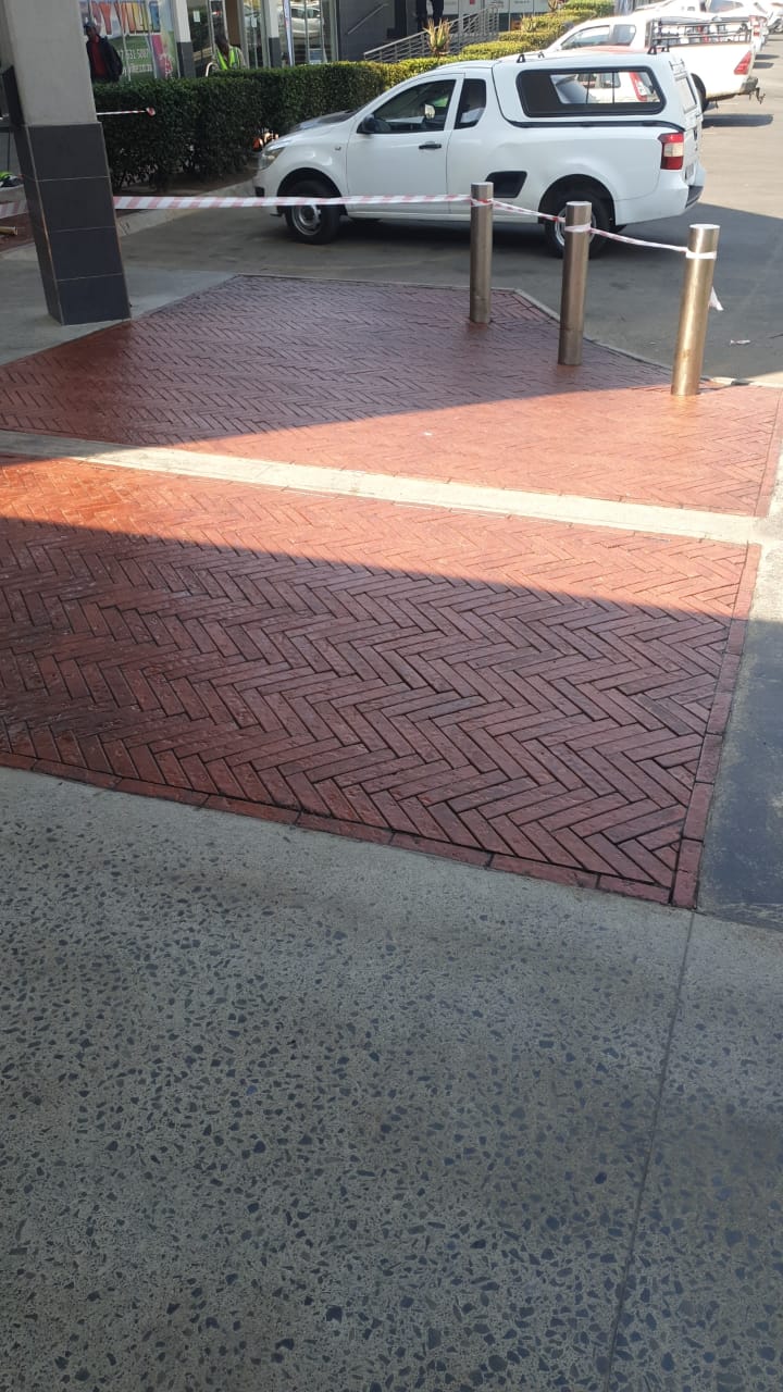 Stone Sealer applied to herringbone red paver entrance of shopping centre showing enhanced colour