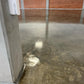 Industrial warehouse floor with stone sealer high-gloss finish reflecting overhead lighting