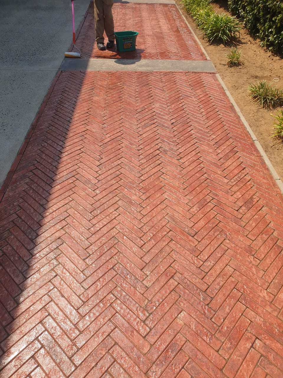 Rhinoluxe Stone Sealer satin finish on red brick paving at mall entrance with bollards