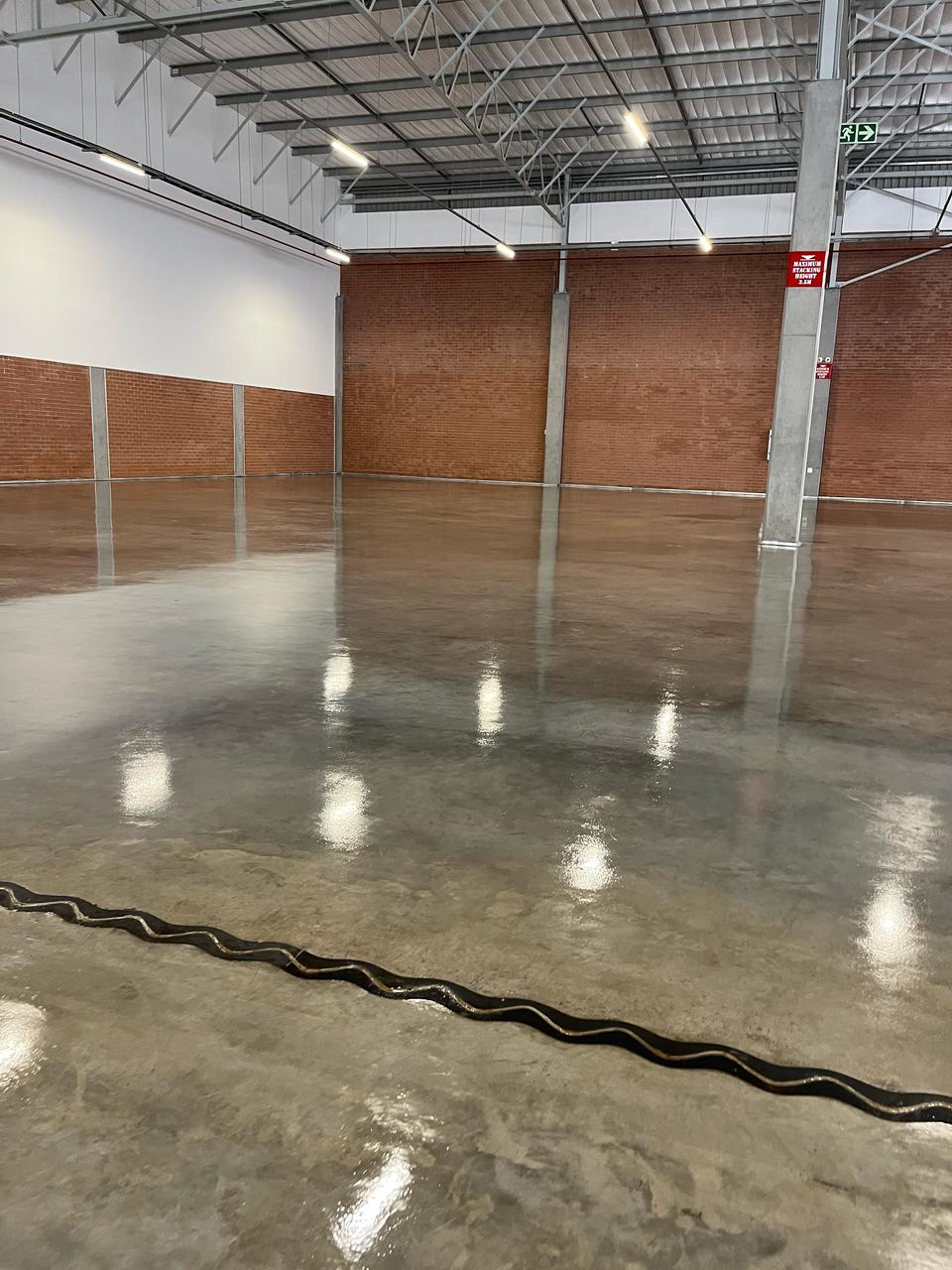 Warehouse concrete floor with professional stone sealer application and satin-gloss sheen