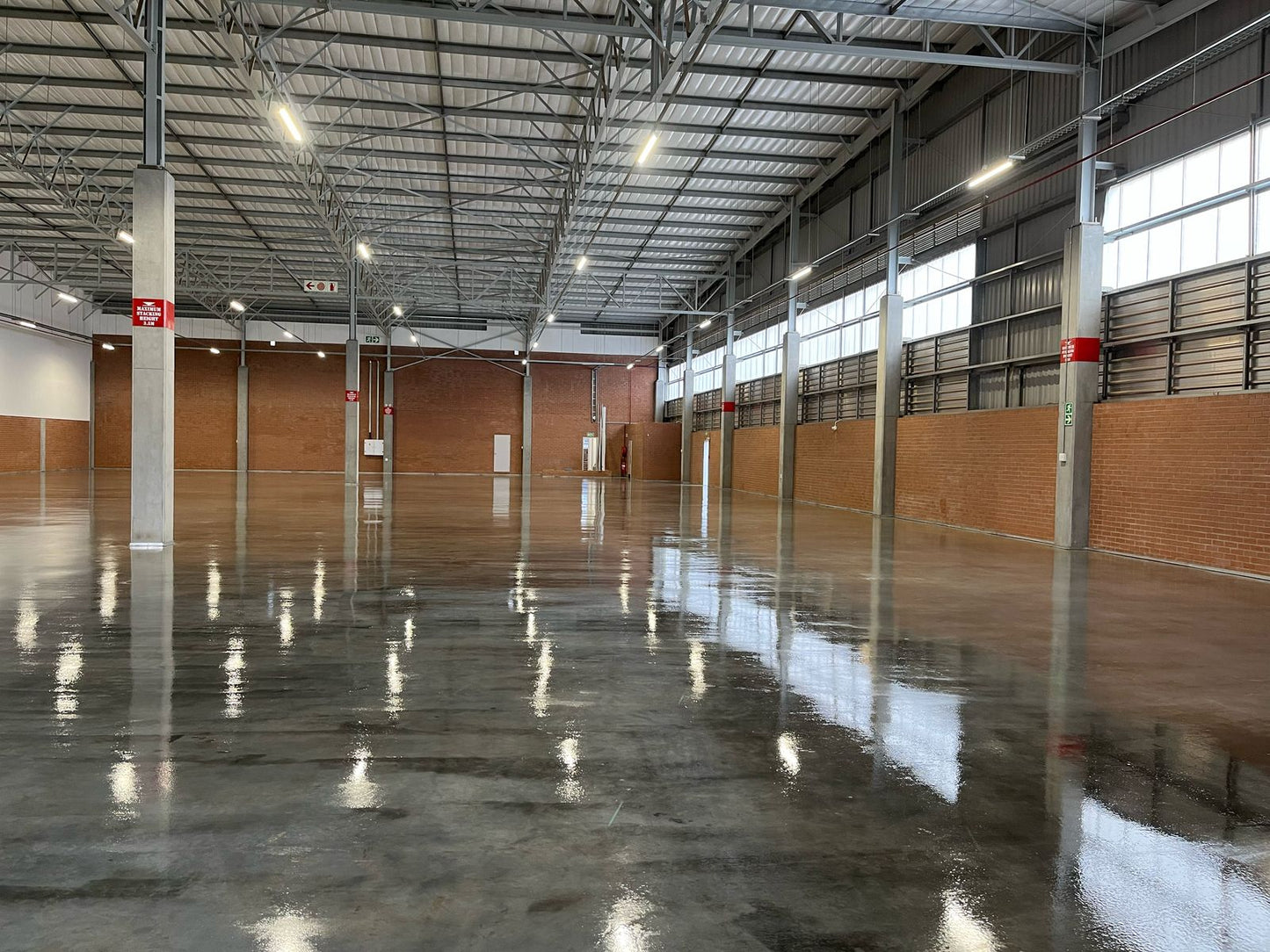 Reflective sealed concrete warehouse floor demonstrating stone sealer gloss performance