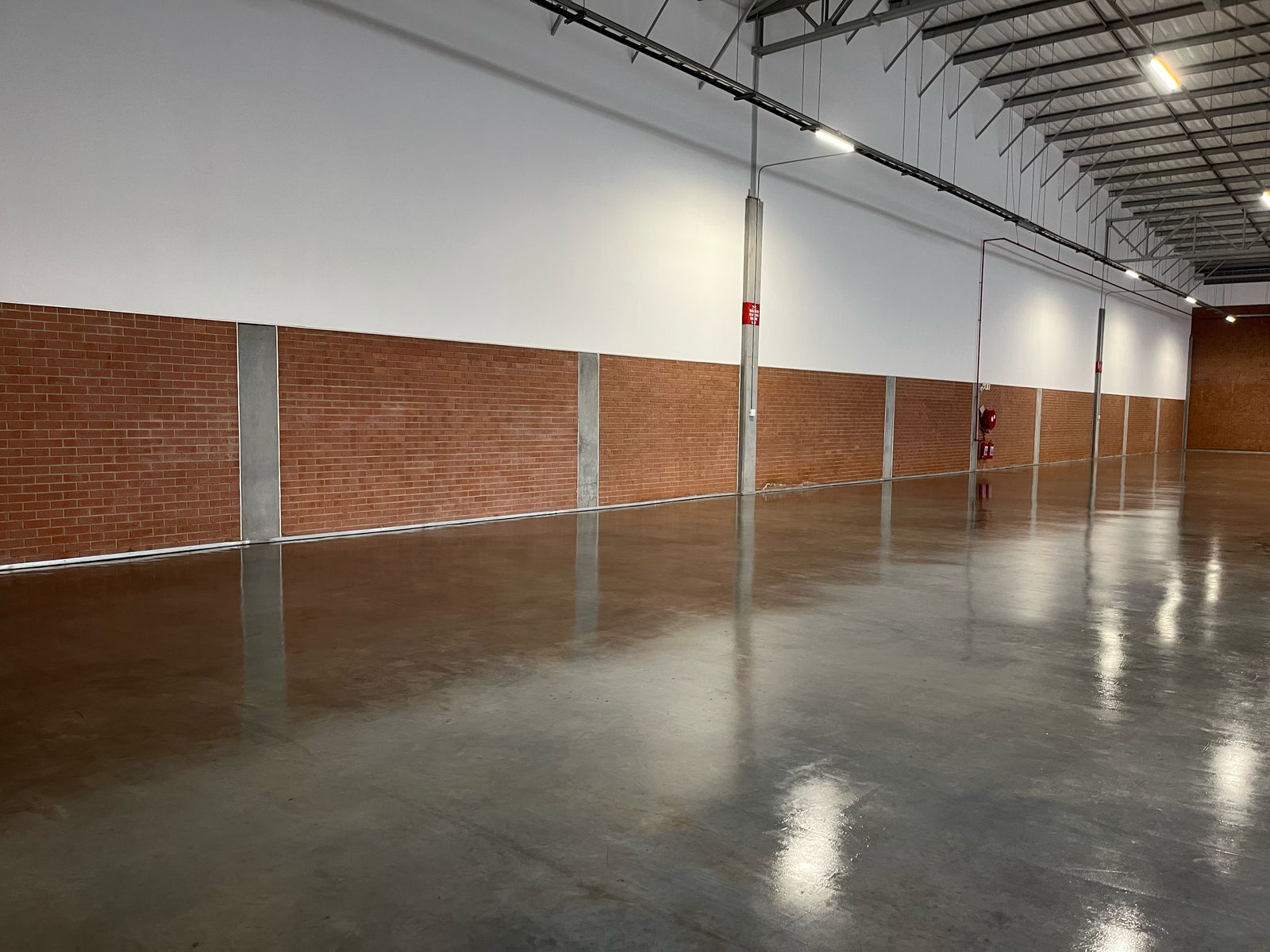 Industrial floor sealed with Rhinoluxe Stone Sealer showing smooth high-gloss concrete finish