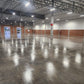 Large warehouse concrete floor sealed with Rhinoluxe Stone Sealer showing high-gloss reflective finish