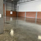 Sealed warehouse concrete floor with mirror-like gloss finish and brick accent walls